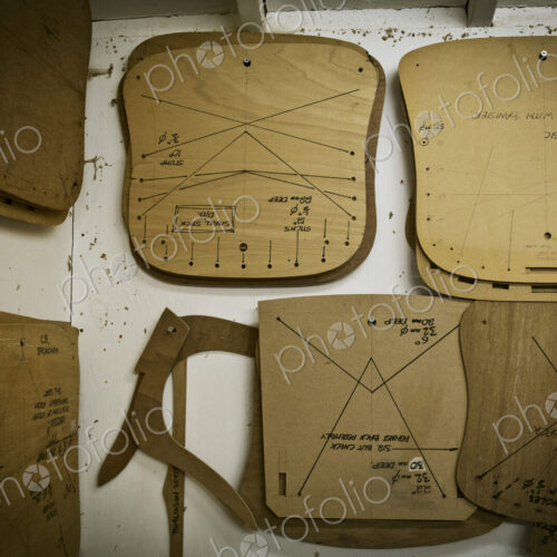 A furniture workshop, wooden chair component templates hanging on the wall. A furniture workshop, wooden chair component templates hanging on the wall.