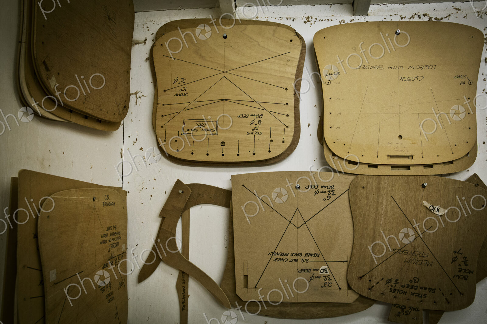 A furniture workshop, wooden chair component templates hanging on the wall.