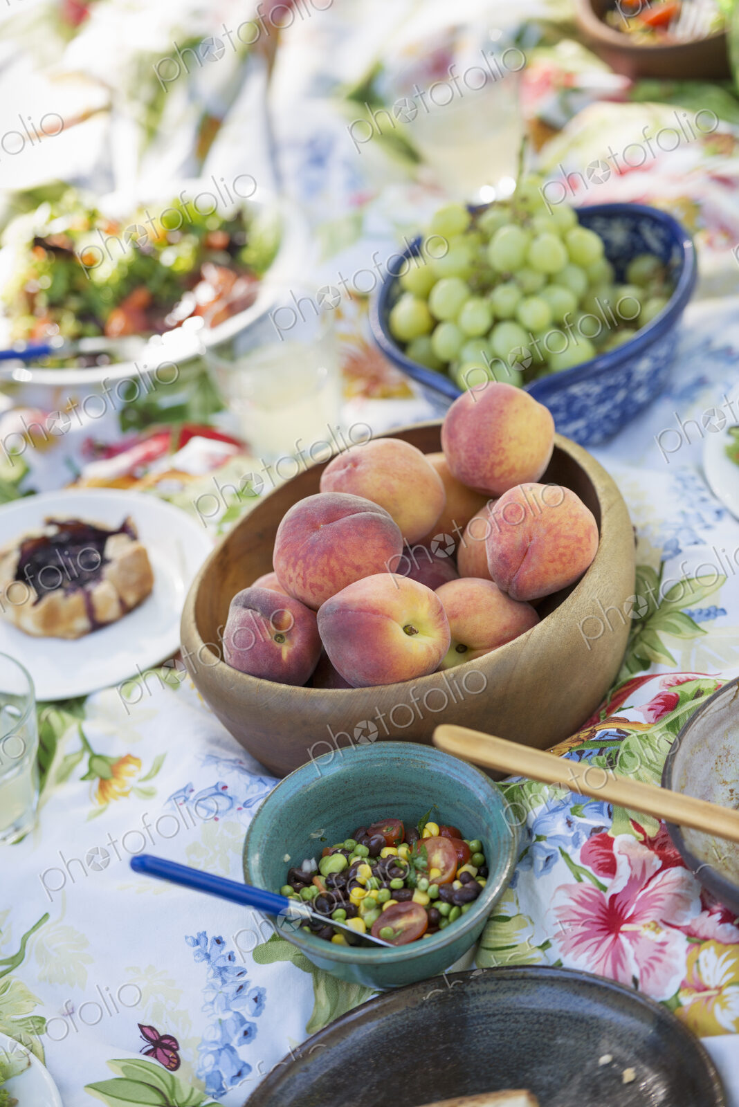 A garden table laid with a buffet of salad, fresh vegetables and fruit.