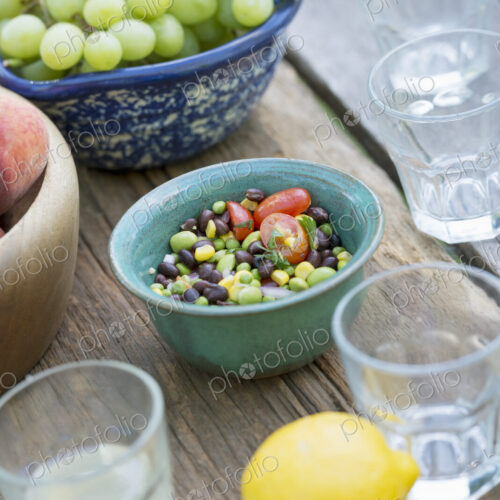 A garden table laid with a buffet of salad, fresh vegetables and fruit.