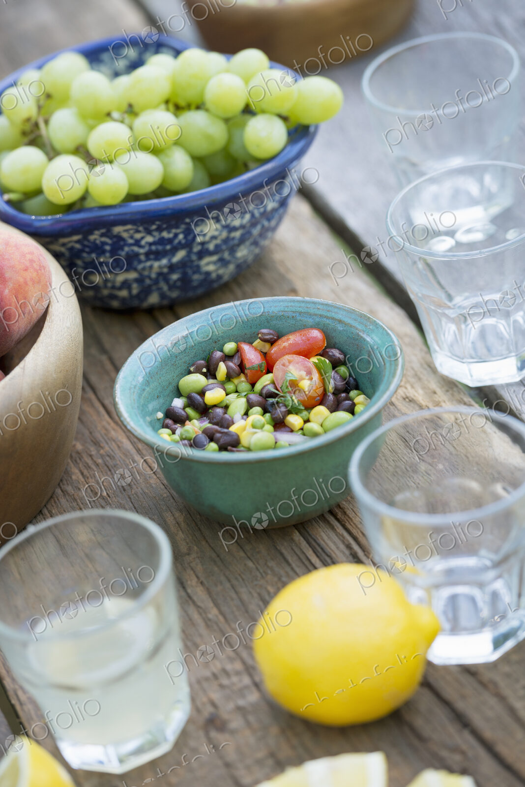 A garden table laid with a buffet of salad, fresh vegetables and fruit.