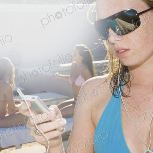 A girl in sunglasses listening to music on headphones.