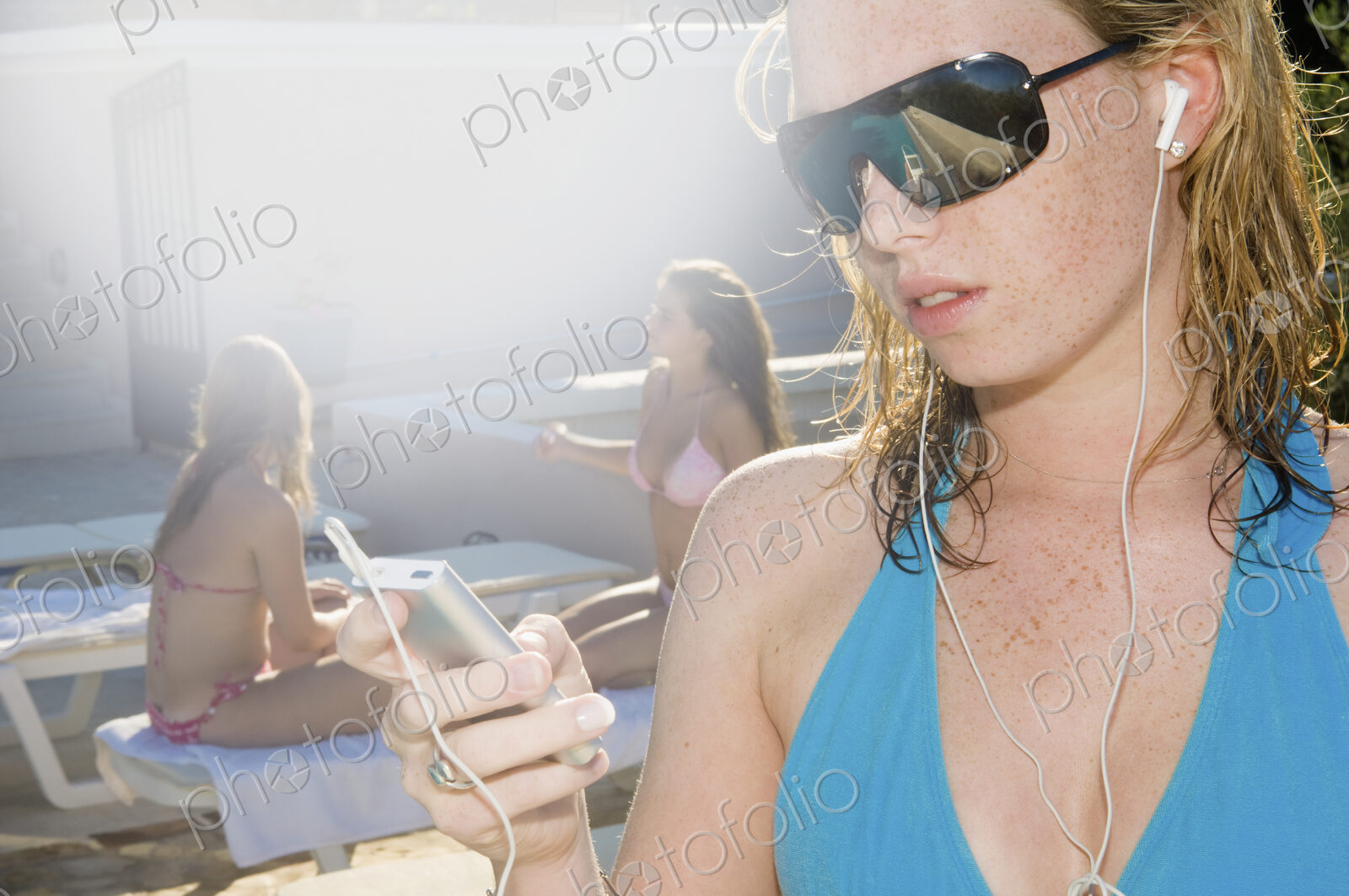 A girl in sunglasses listening to music on headphones.