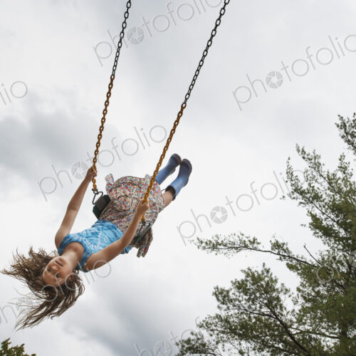 A girl on a rope swing, high in the air A girl on a rope swing, high in the air