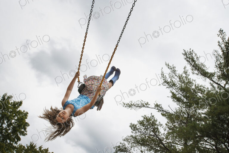 A girl on a rope swing, high in the air