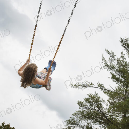 A girl on a rope swing, high in the air A girl on a rope swing, high in the air