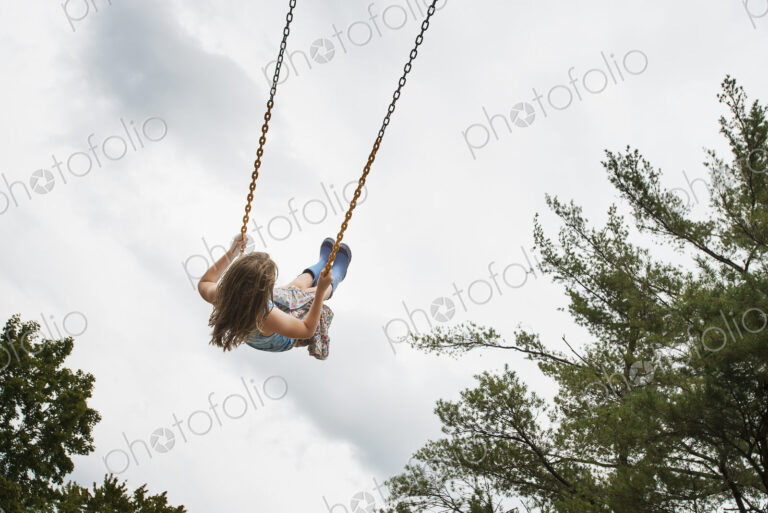 A girl on a rope swing, high in the air