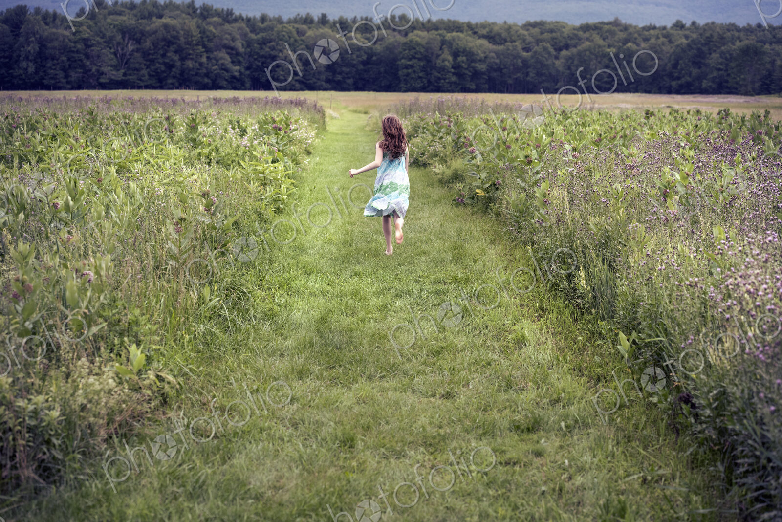 A girl running through a meadow in summer.