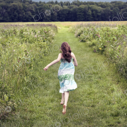A girl running through a meadow in summer. A girl running through a meadow in summer.