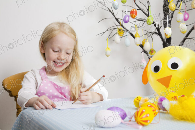 A girl sitting at a table drawing.