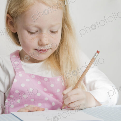 A girl sitting at a table drawing. A girl sitting at a table drawing.
