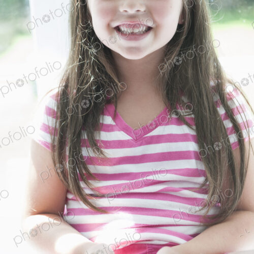 A girl sitting playing, holding a smart phone. A girl sitting playing, holding a smart phone.
