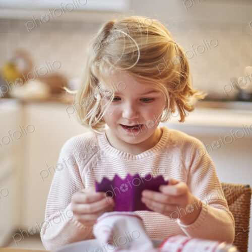 A girl unwrapping a paper hat out of a Christmas cracker. A girl unwrapping a paper hat out of a Christmas cracker.
