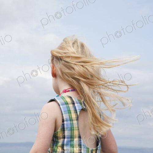 A girl with her hair blowing in the wind. A girl with her hair blowing in the wind.