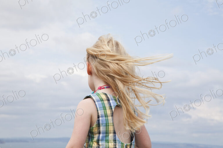 A girl with her hair blowing in the wind.