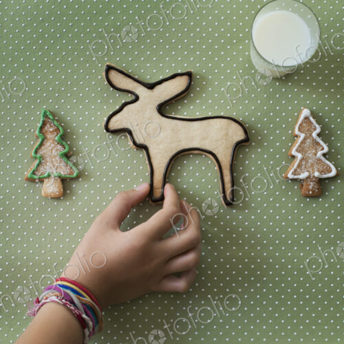A girl's hand arranging an organic homemade Christmas cookies in the shape of a… A girl's hand arranging an organic homemade Christmas cookies in the shape of a…