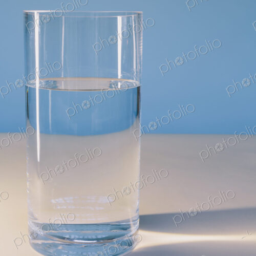 A glass of filtered water on a white surface.