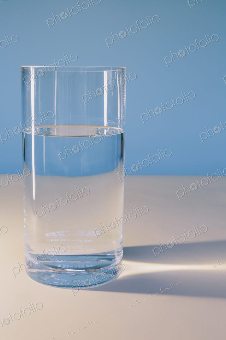 A glass of filtered water on a white surface.