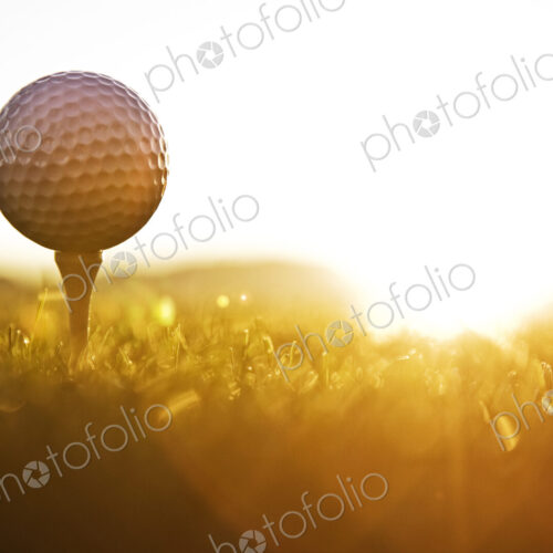 A golf ball on a tee and ready to be hit as the sun comes up. A golf ball on a tee and ready to be hit as the sun comes up.