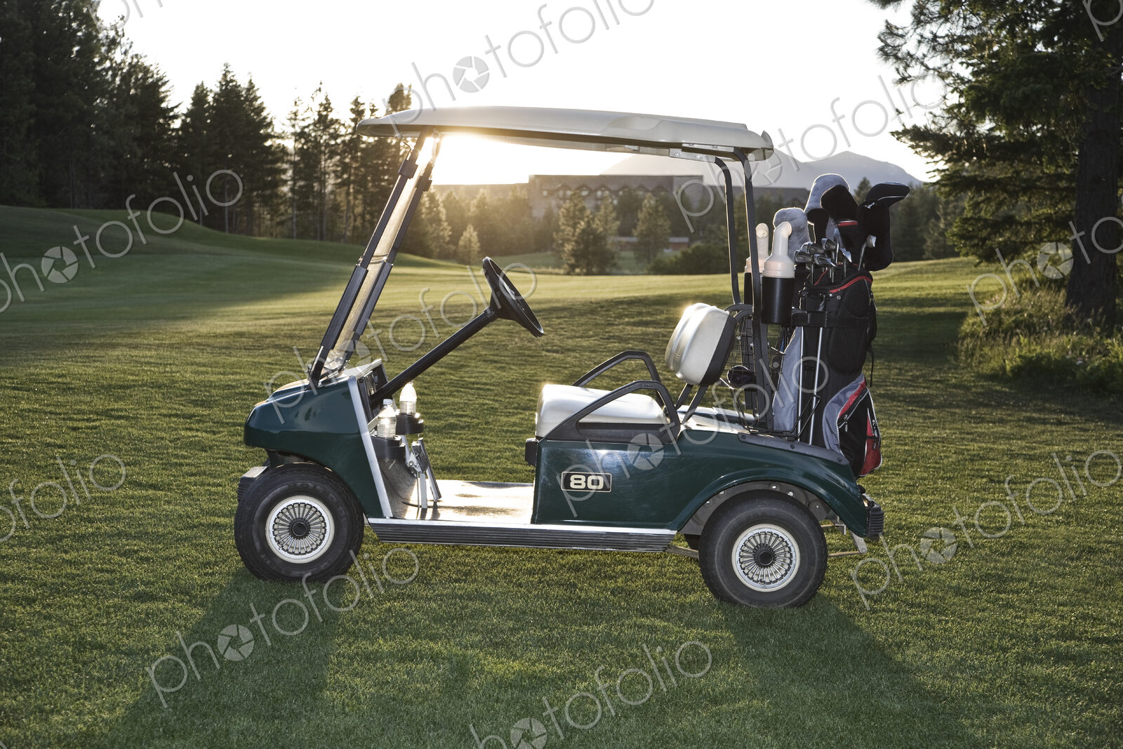 A golf cart with bags sitting on a golf course.