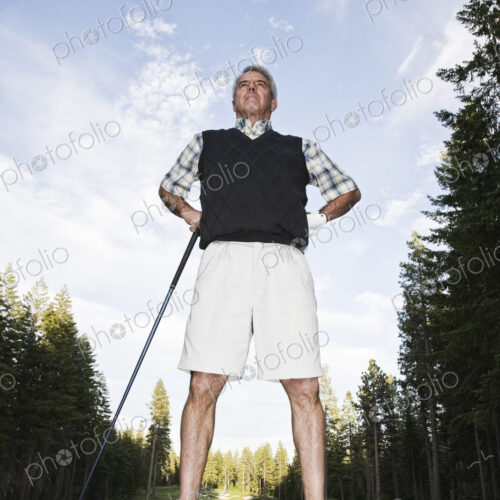 A golfer leaning on his golf club at the tee. A golfer leaning on his golf club at the tee.