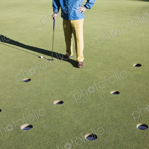 A golfer with way too many choices in possible putts on the greeen of a golf course.