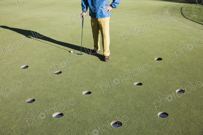 A golfer with way too many choices in possible putts on the greeen of a golf course.
