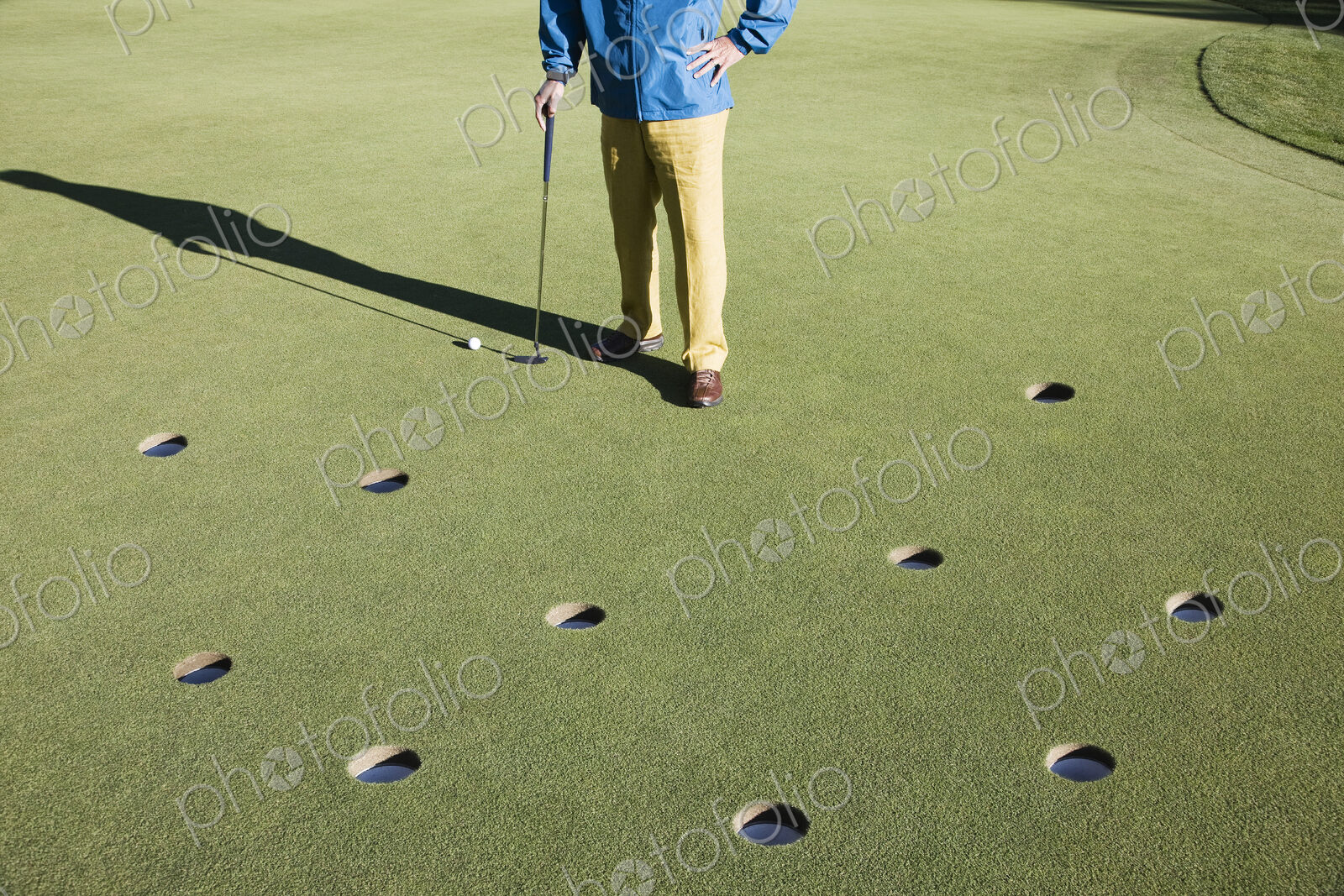 A golfer with way too many choices in possible putts on the greeen of a golf course.