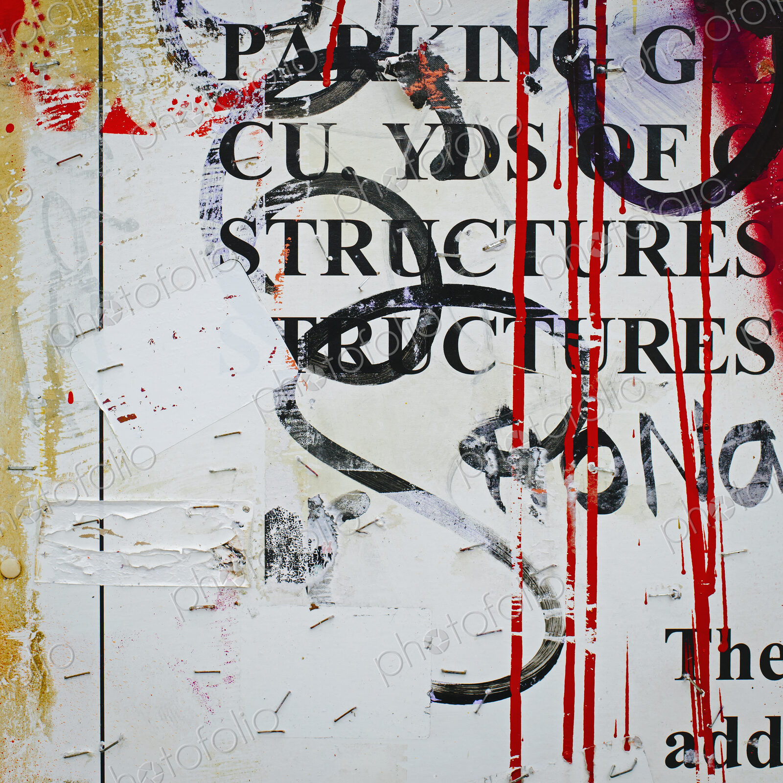A graffiti covered wall in a city. Streaks of paint drips and printed messages covered…