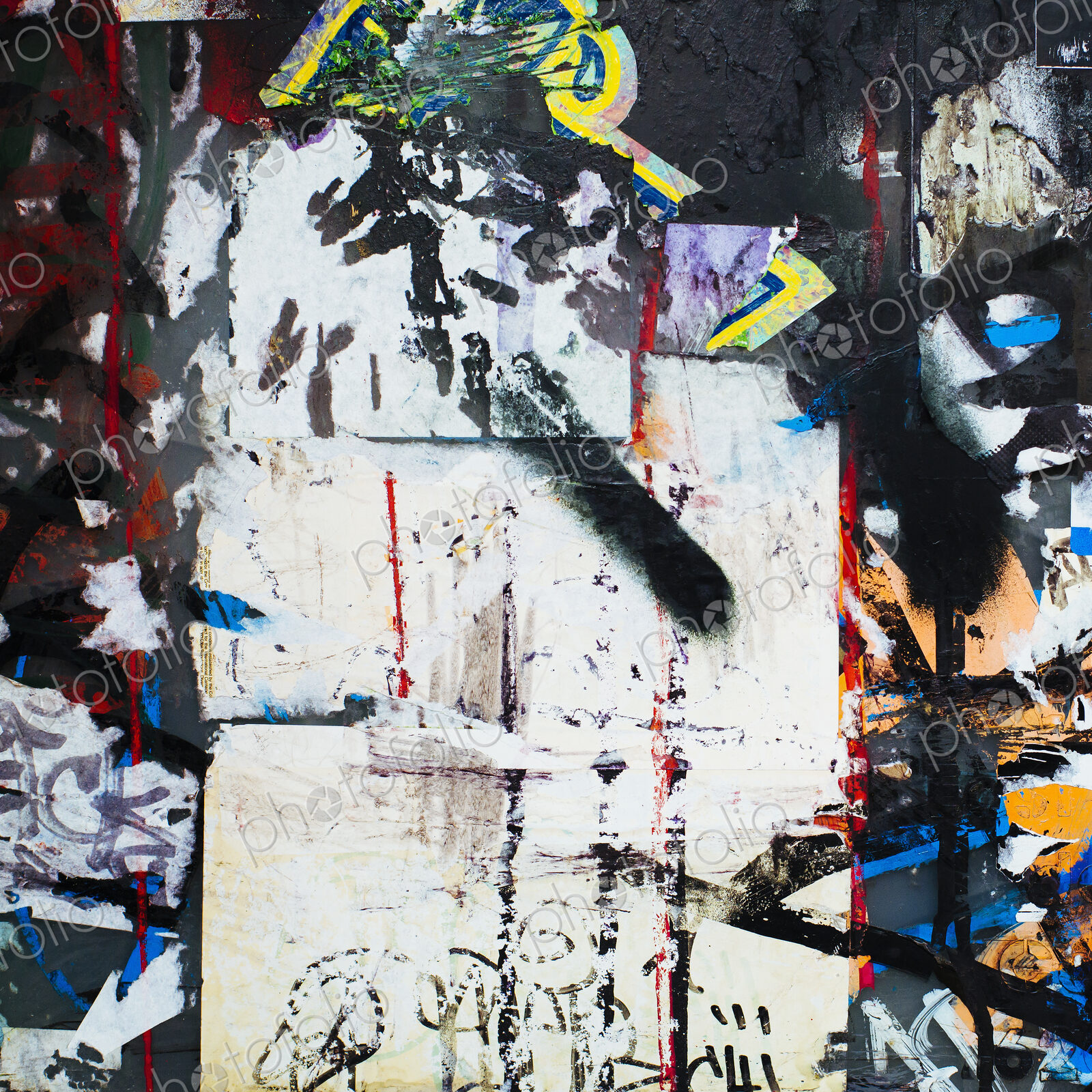 A graffiti covered wall in a city. Streaks of paint drips and spraypaint tags.