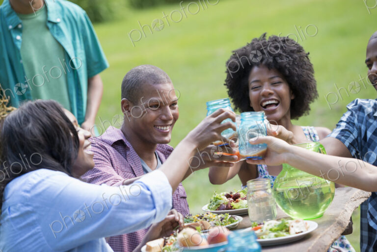 A group of adults and young people at a meal in the garden of a farmhouse.