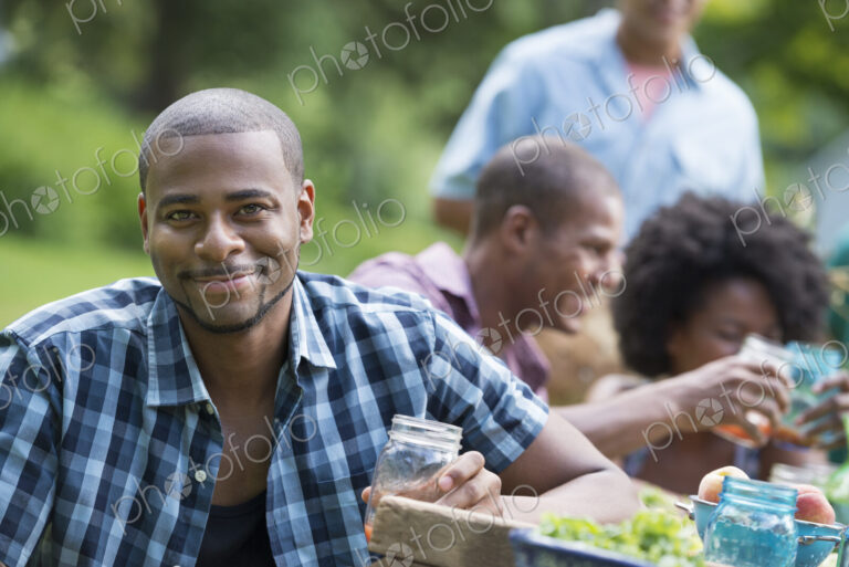 A group of adults and young people at a meal in the garden of a farmhouse.