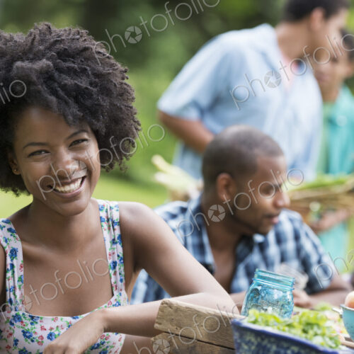 A group of adults and young people at a meal in the garden of a farmhouse. A group of adults and young people at a meal in the garden of a farmhouse.
