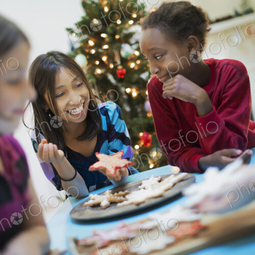 A group of children around a table, decorating organic Christmas cookies. A group of children around a table, decorating organic Christmas cookies.