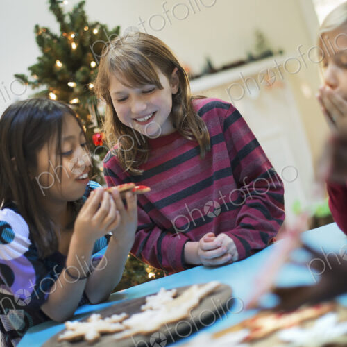 A group of children around a table, decorating organic Christmas cookies. A group of children around a table, decorating organic Christmas cookies.