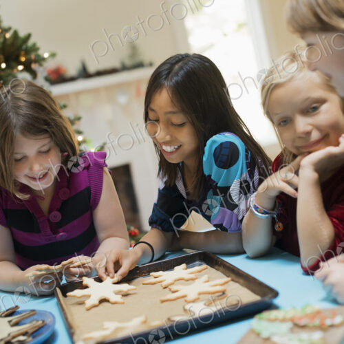 A group of children around a table, decorating organic Christmas cookies. A group of children around a table, decorating organic Christmas cookies.