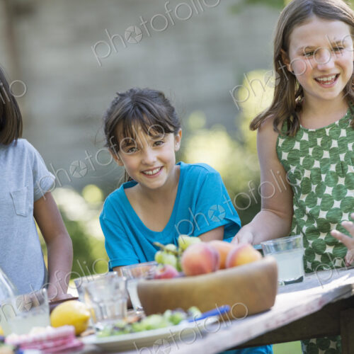 A group of children around a table, eating fresh fruitss and salads. A group of children around a table, eating fresh fruitss and salads.
