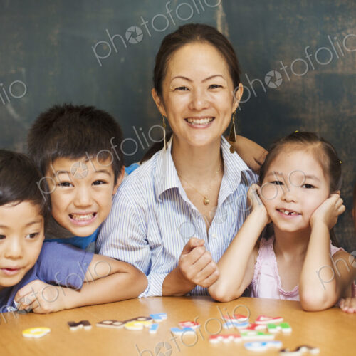 A group of children, boys and girls in a classroom with their teacher.