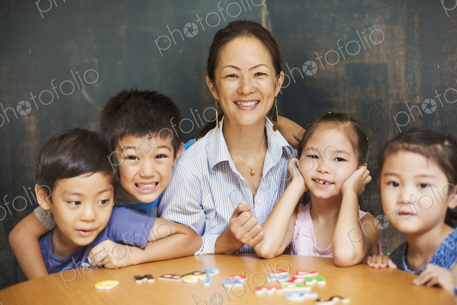 A group of children, boys and girls in a classroom with their teacher.