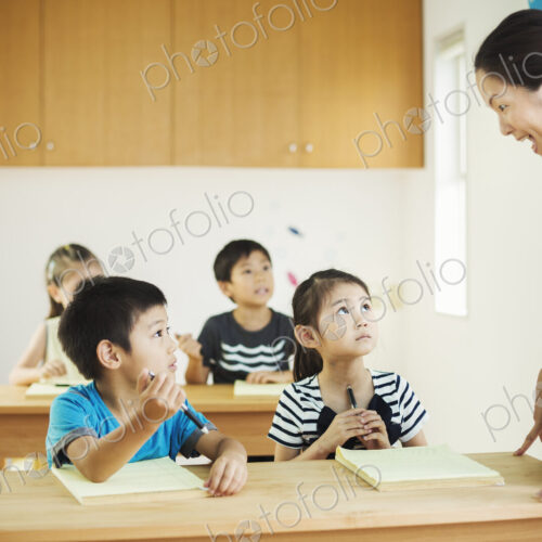 A group of children in a classroom with their female teacher.