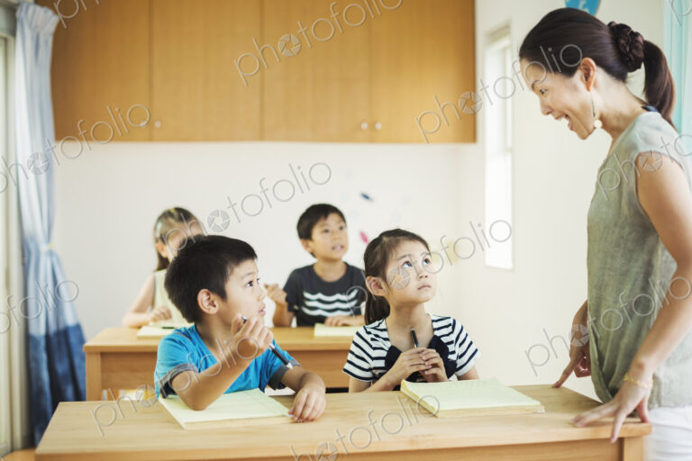 A group of children in a classroom with their female teacher.