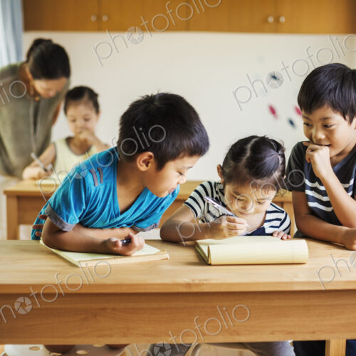 A group of children in a classroom with their female teacher.