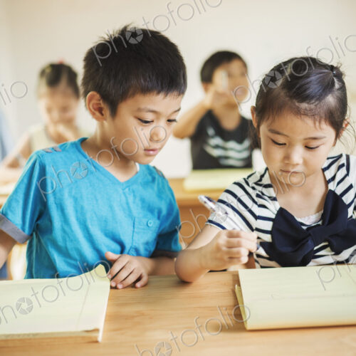 A group of children in a classroom, working together, boys and girls.