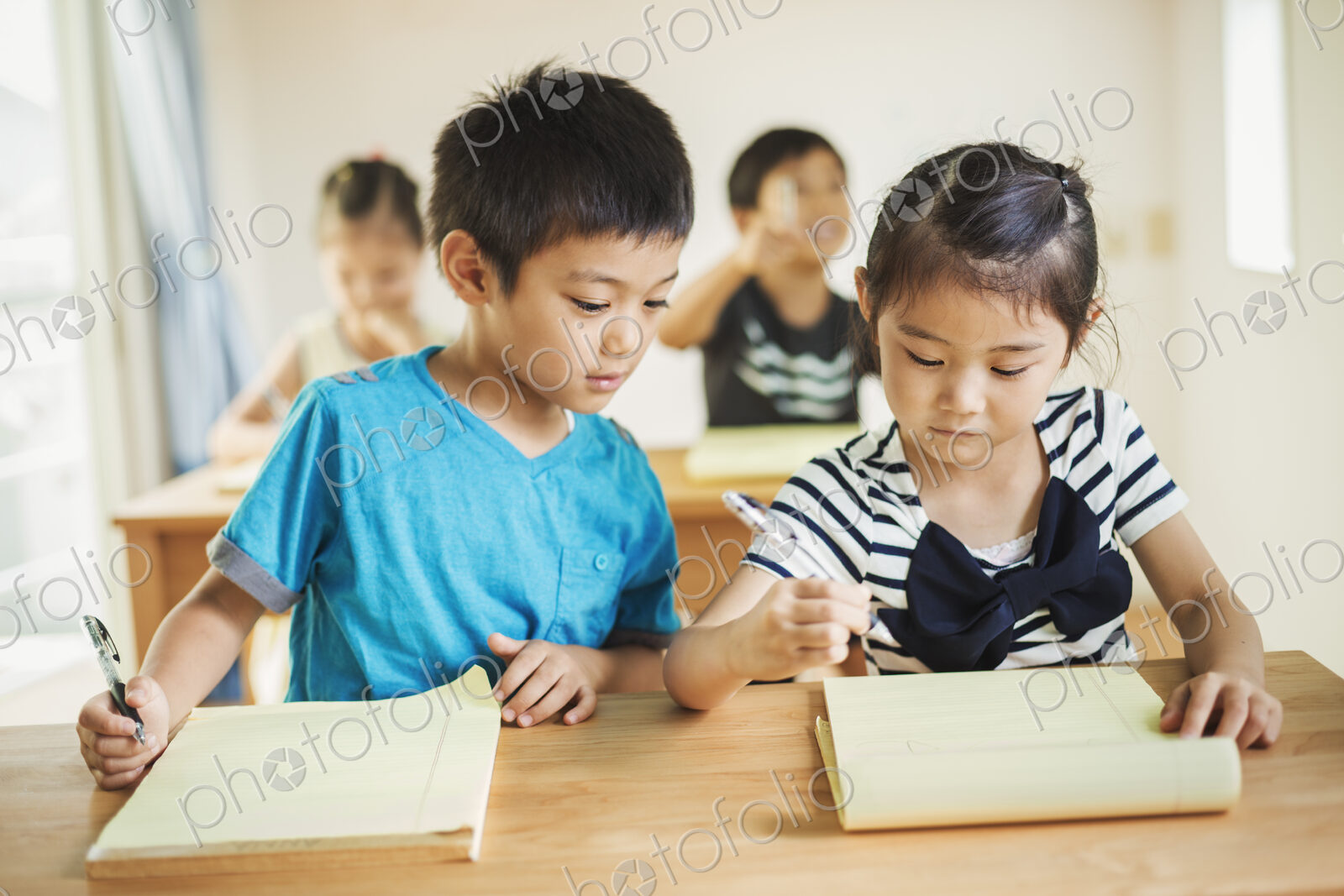A group of children in a classroom, working together, boys and girls.