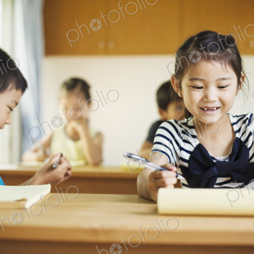 A group of children in a classroom, working together, boys and girls.