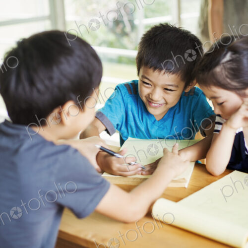 A group of children in a classroom, working together, boys and girls.