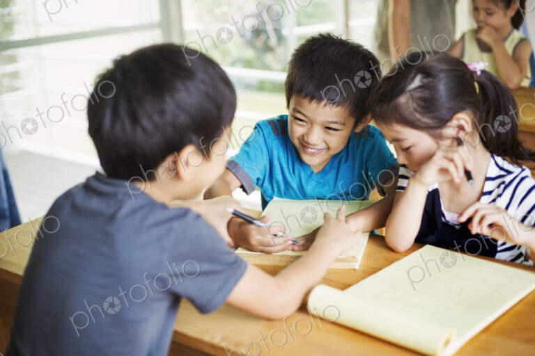 A group of children in a classroom, working together, boys and girls.