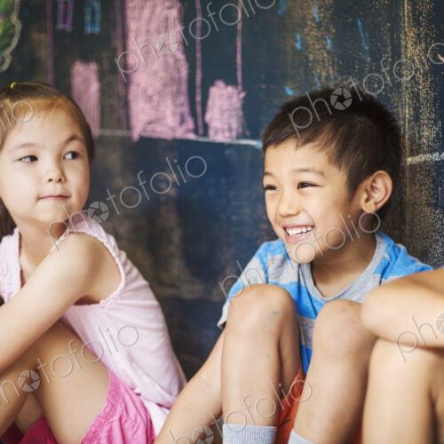 A group of children in school. Boys and girls sitting on the floor. A group of children in school. Boys and girls sitting on the floor.
