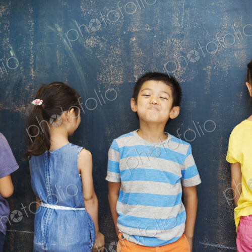 A group of children in school. Four children standing by the blackboard. A group of children in school. Four children standing by the blackboard.