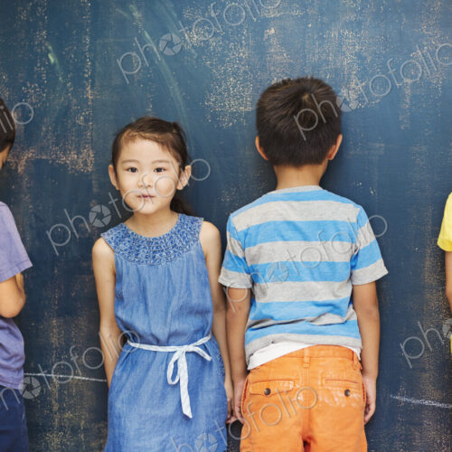 A group of children in school. Four children standing by the blackboard. A group of children in school. Four children standing by the blackboard.